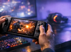 Рука держит портативную игровую консоль с активной игрой на экране.