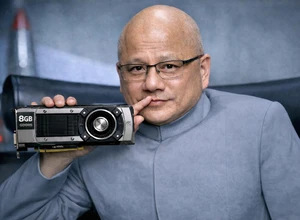 Мужчина в сером костюме держит видеокарту, задумчиво прикасаясь ко рту.