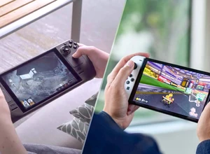 Два человека играют на портативных игровых консолях, одна с темным, другая с белым корпусом.