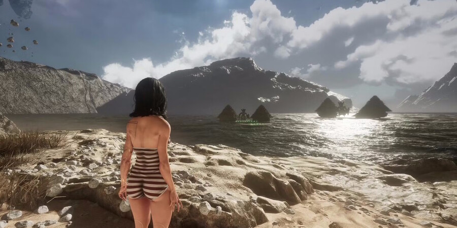 Женщина в купальнике стоит на берегу моря, смотрит на горы и облака.